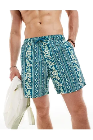 ASOS Shorts de baño a rayas de largo medio con estampado tropical de -Azul