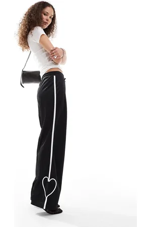 Monki Pantalones de chándal negros de pernera recta con raya y corazón blancos de