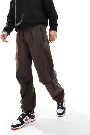Nike Pantalones marrones extragrandes de tejido liso técnico Tech de