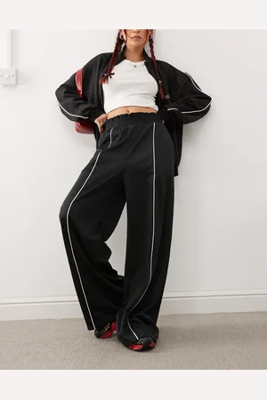 Monki Pantalones de chándal negros de pernera ancha sin cierres con raya delantera de