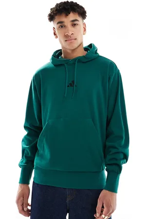adidas Sudadera verde universitario y negra con capucha de felpa de rizo Feelcozy de adidas Essentials