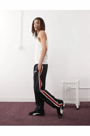 New Era Pantalones de chándal de pernera ancha con banda lateral de
