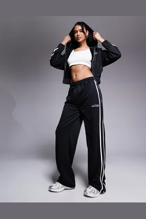 Kaiia Joggers negros de pernera ancha con raya en el lateral y logo de Studio (parte de un conjunto)