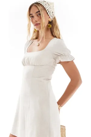 The Frolic Vestido corto color de mezcla de lino con mangas abullonadas, lazada en la espalda, escote cuadrado y ribete de encaje exclusivo de -Neutro