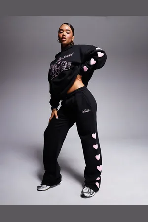 Kaiia Joggers negros y rosas de pernera ancha con estampado del logo y corazones en relieve de (parte de un conjunto)