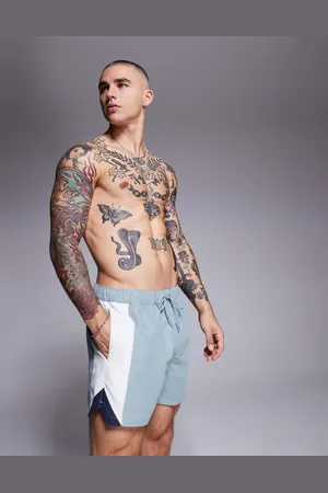 ASOS Shorts de baño cortos azules con diseño de paneles cosidos y abertura lateral de