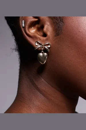 Kaiia Pendientes dorados con diseño colgante de lazo y corazón de