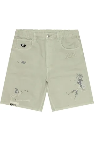 A Bathing Ape Pantalones vaqueros cortos con manchas de pintura