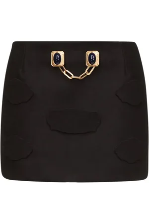 AREA Falda corta con botones de gemas